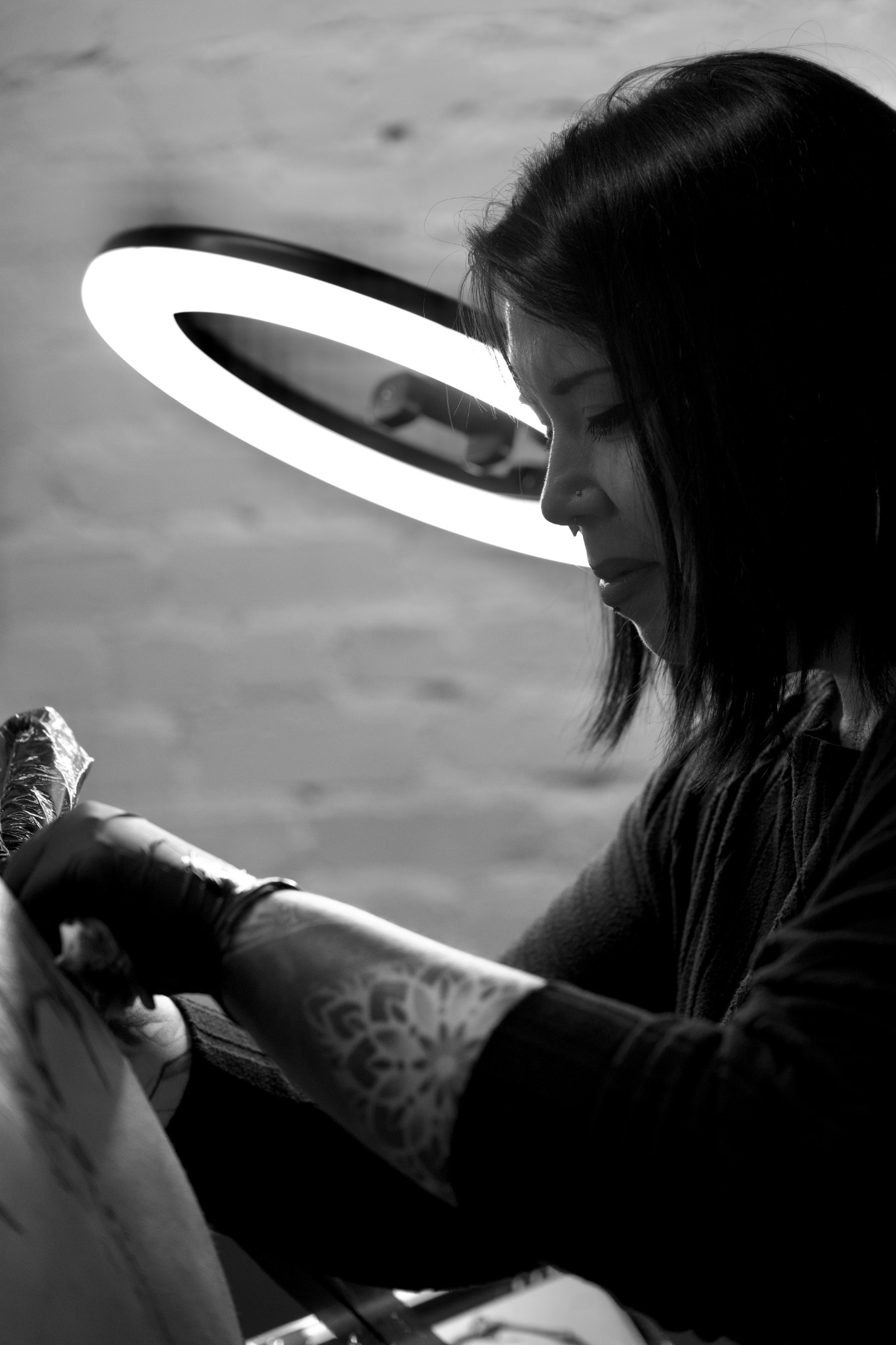Audreyanna tattooing under a ring light