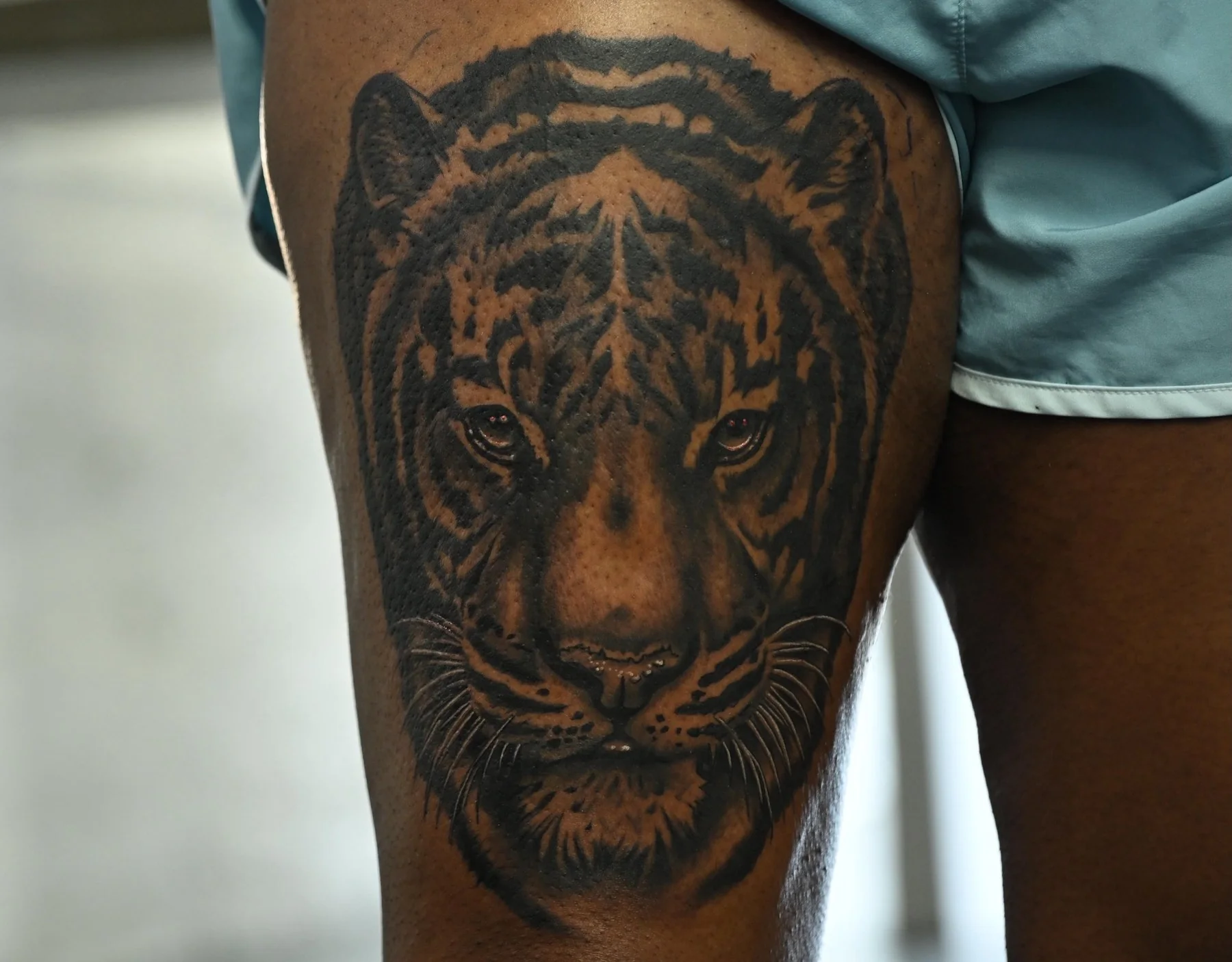 Black and grey tiger portrait tattoo on the thigh by Audreyanna Gonzales